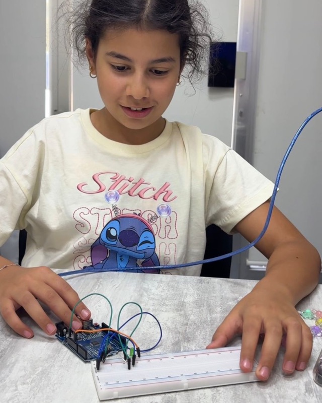RoboStars student wiring an Arduino microcontroller on a breadboard