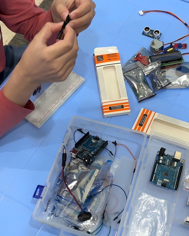 Arduino Uno boards, sensors, and breadboard components used in RoboStars workshops