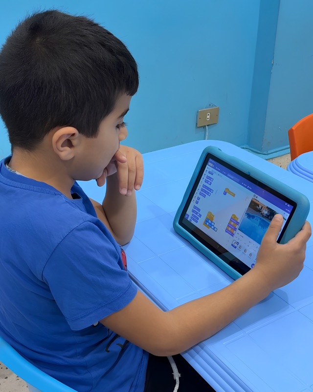 RoboStars student following an advanced block-based coding lesson on a tablet